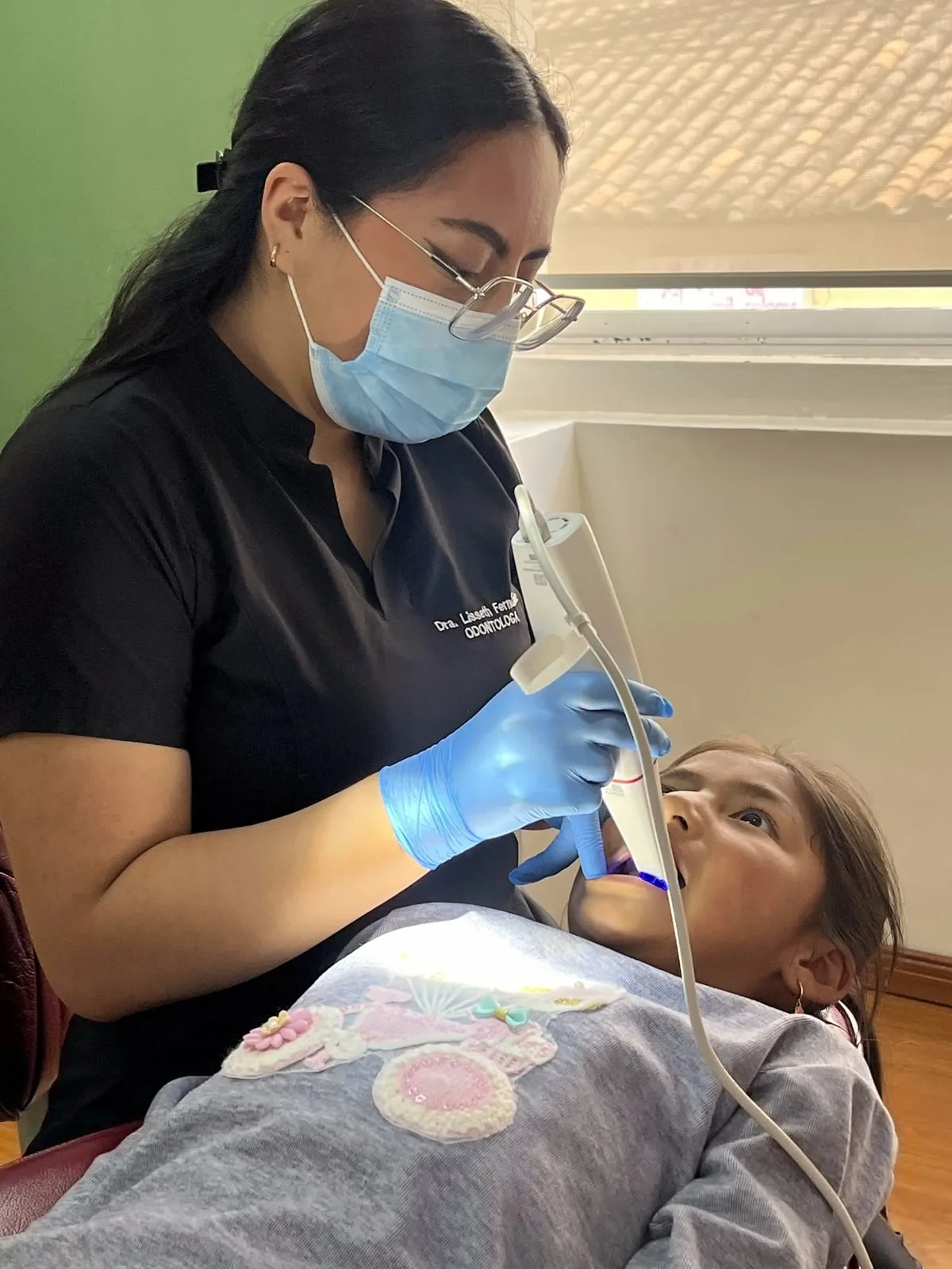 Odontóloga atendiendo a una niña en el sillón dental de World Dental, Conocoto